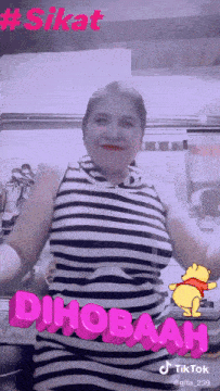 a woman in a black and white striped dress is dancing with a winnie pooh sticker