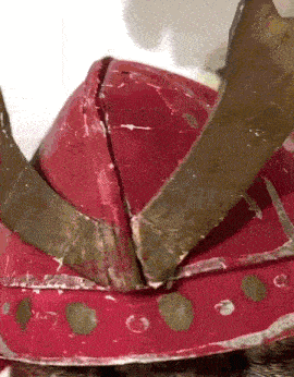 a close up of a red helmet with a crown on it