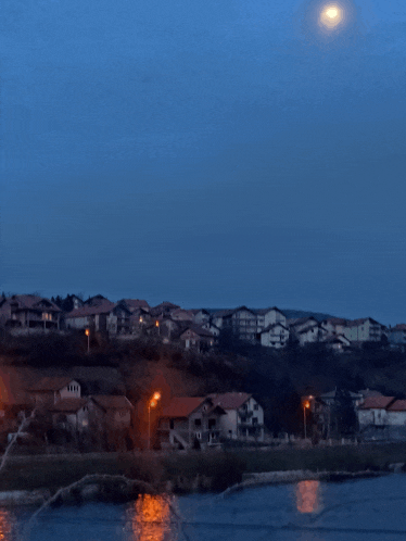 a full moon shines over a small town