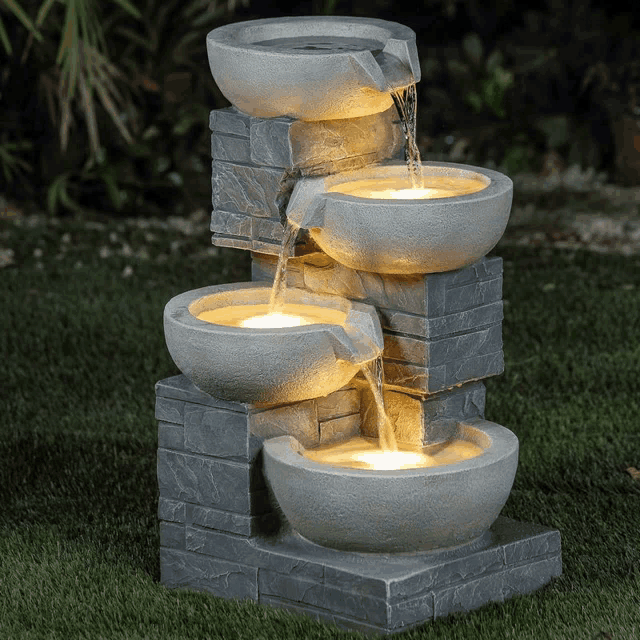 a water fountain with four bowls and lights on it
