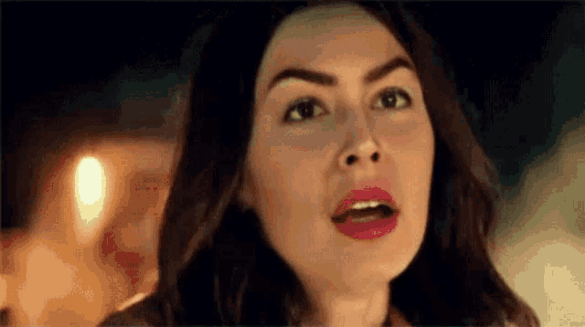 a close up of a woman 's face with a surprised expression on her face .