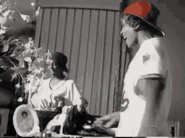 a man wearing a red hat is standing in front of a mirror in a room