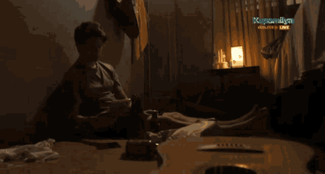 a man playing a guitar in a dark room with the words kapamilya online live on the bottom right
