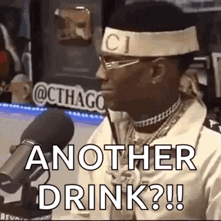 a man wearing a headband and glasses is sitting in front of a microphone and says `` another drink ? ''
