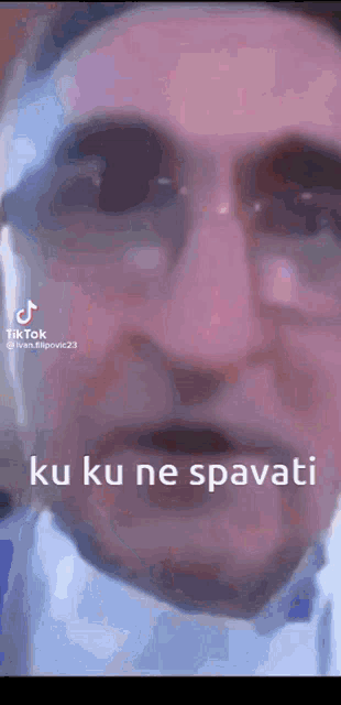 a close up of a man 's face with the words ku ku ne spavati written on it
