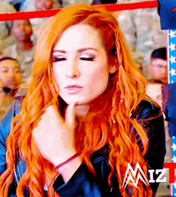 a woman with red hair is in a wrestling ring with miz written on the bottom right