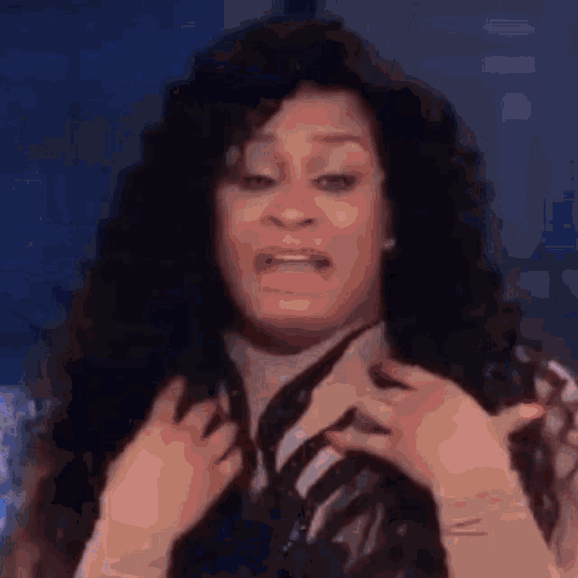a woman with curly hair is making a funny face while wearing gloves .