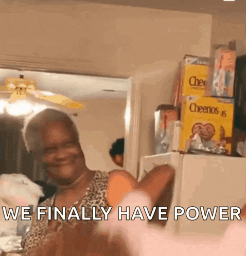 an elderly woman is standing in front of a refrigerator with boxes of cheerios on the shelf .