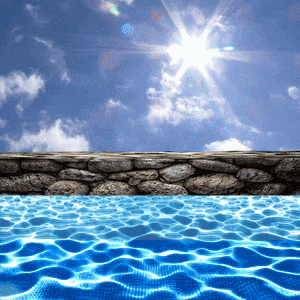 a swimming pool with a stone wall and the sun shining through the clouds