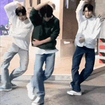a group of young men are standing next to each other and dancing .