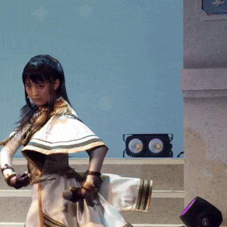 a woman in a white and gold dress is dancing on stage