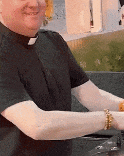 a man in a black shirt with a clergy collar