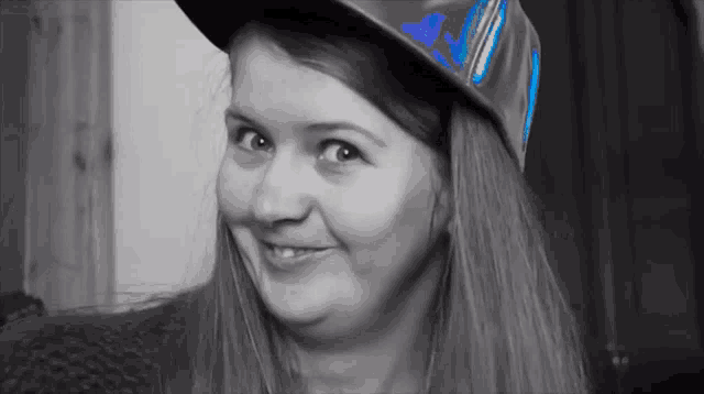 a black and white photo of a woman wearing a blue adidas hat