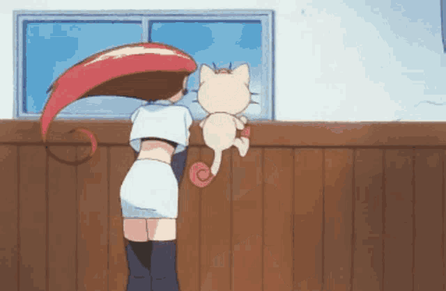 a woman and a cat are standing next to each other in front of a window