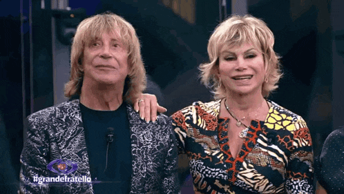 a man and a woman are standing next to each other with the hashtag grandefratello on the bottom