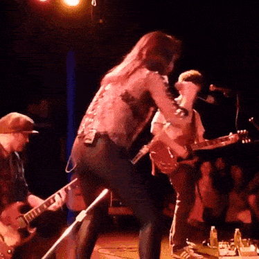 a man playing a guitar and a woman playing a guitar on stage