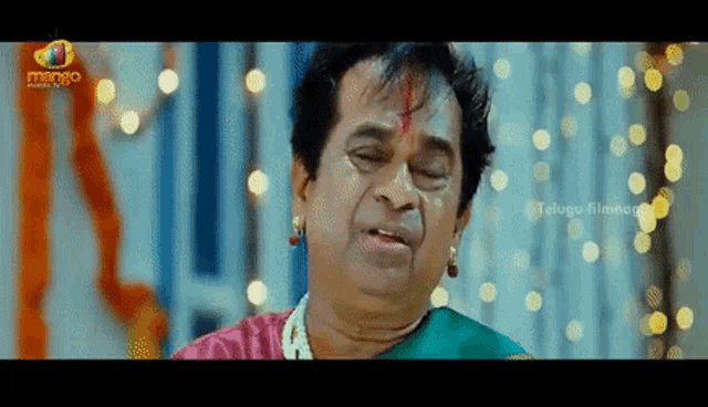a man with a red bindi on his forehead is making a funny face