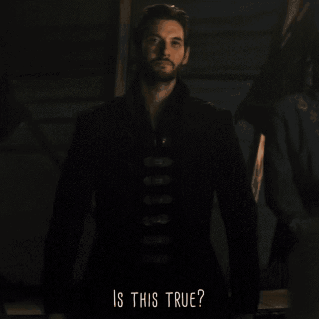 a man with a beard is standing in a dark room with the words " is this true " below him