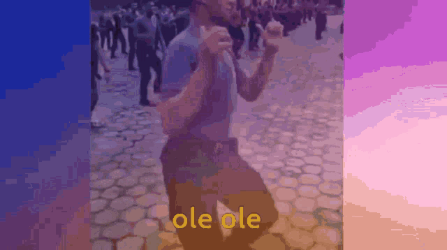 a man is dancing in front of a crowd and the word ole ole is on the bottom right