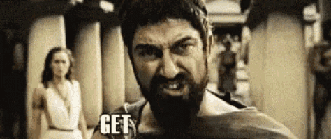a man with a beard is standing in front of a woman in a white dress and says `` get '' .