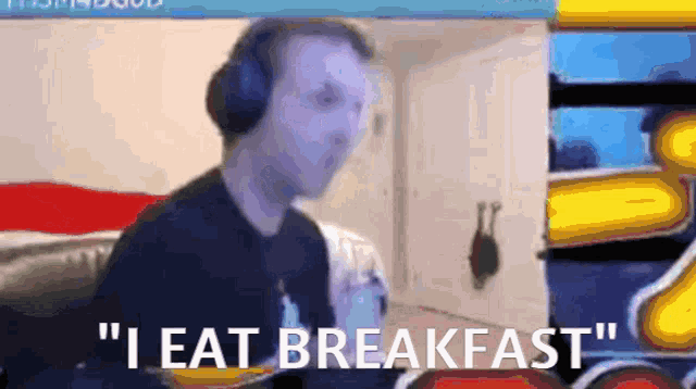 a man wearing headphones says " i eat breakfast " in front of a screen