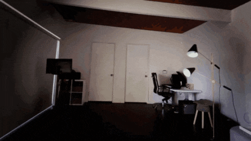 a dimly lit room with a desk and chair