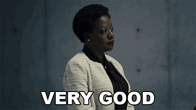 a woman says " very good " in front of a gray wall