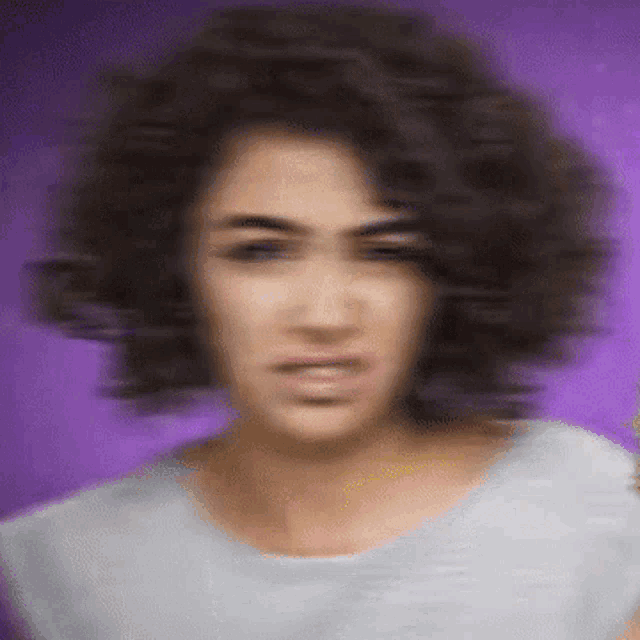 a blurry picture of a woman 's face with a purple background