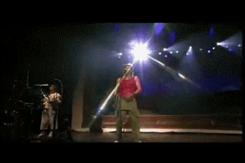 a man singing into a microphone on stage