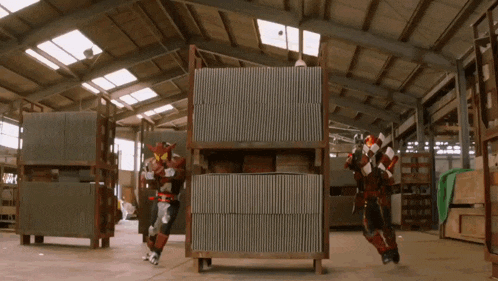 a man in a red and black costume is standing in a large warehouse