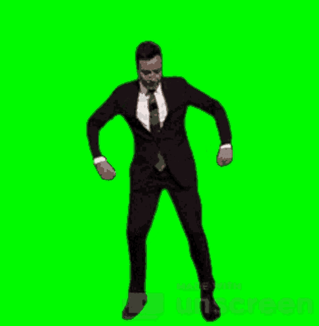 a man in a suit dancing on a green screen