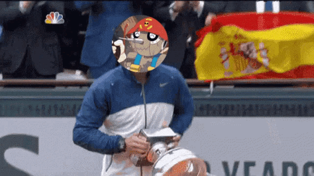a man holding a trophy with a cartoon character on his head