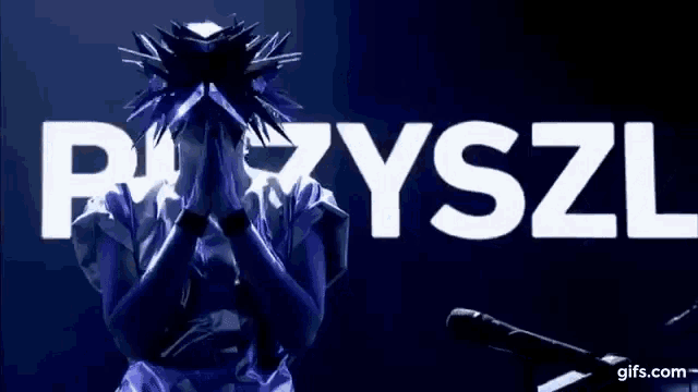 a person is standing in front of a microphone with the word epiyszi written in white letters .