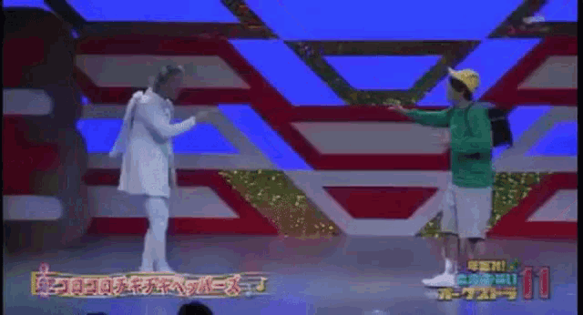 a man in a green shirt is standing next to a man in a white coat on a stage .