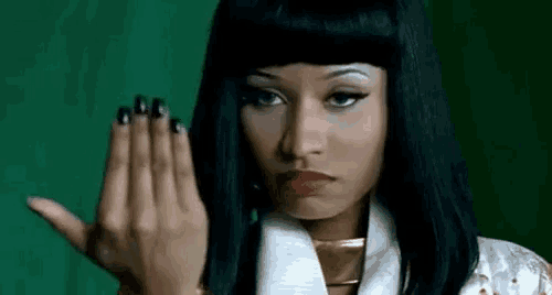 a woman with long black nails is making a hand gesture with her hand .