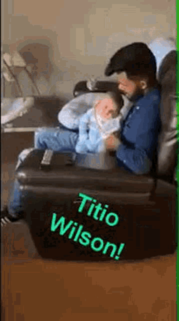 a man is sitting in a chair holding a baby in his lap .