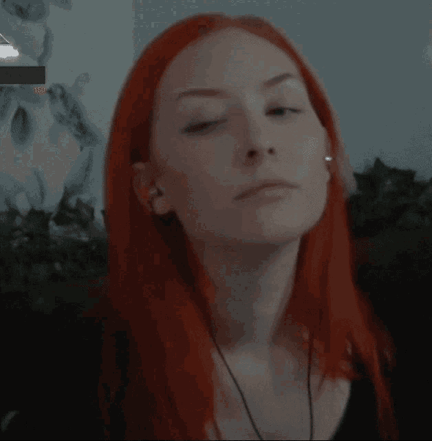 a woman with red hair is making a funny face with her mouth open