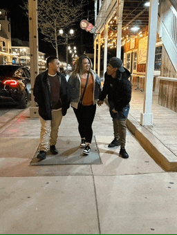 a group of people walking down a sidewalk with a sign that says ' i love you ' on it