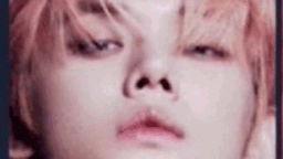 a close up of a person 's face with pink hair and a very small nose .