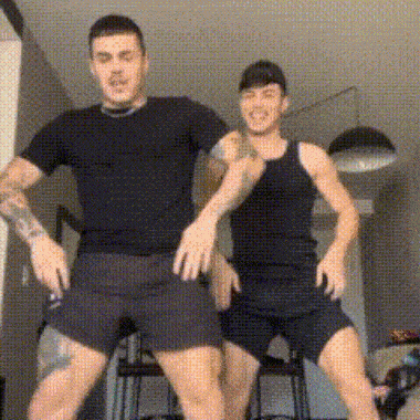 two men are standing next to each other in a room and dancing .