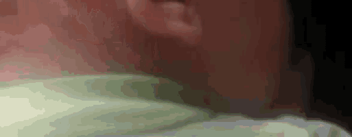 a close up of a person 's neck and ear in a green shirt .