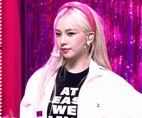 a woman wearing a pink headband and a black shirt that says at ease we
