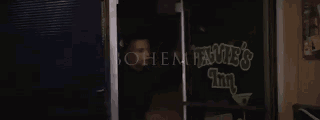 a man is standing in front of a glass door that says bohemia on it