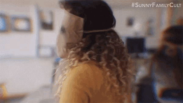 a woman with curly hair is wearing a mask .