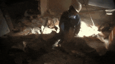 a man wearing a hard hat is working on a pile of rubble