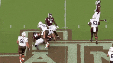 a football player with the number 18 on his jersey is being tackled by another player