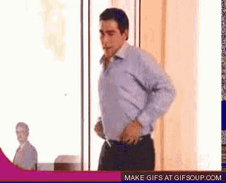 a man is standing in front of a window with a make gifs at gifsoup.com button