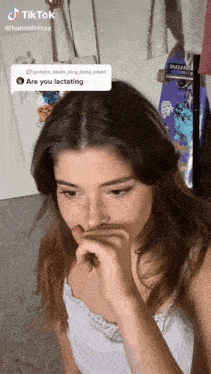 a woman covering her mouth with her hand while a skateboard is in the background