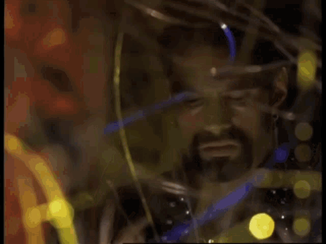 a man with a beard and glasses is surrounded by a bunch of confetti and lights .