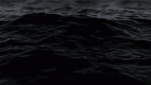 a close up of a black water surface with waves in the ocean